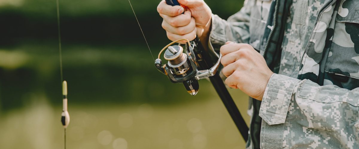 A man fishing on a lake. Guy in a uniform.